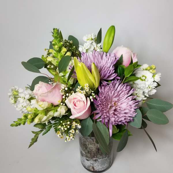 Pink roses and purple chrysanthemums in a glass vase