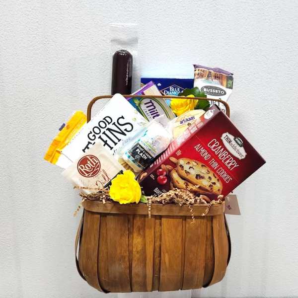 Gift basket with assorted snacks and two yellow flowers