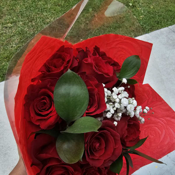 Bouquet of red roses with white baby's breath wrapped in red paper