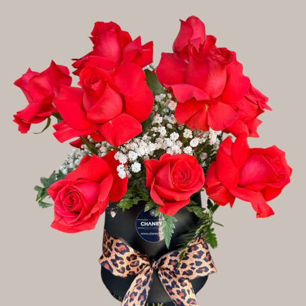 Red roses in a black hatbox with a leopard-print bow