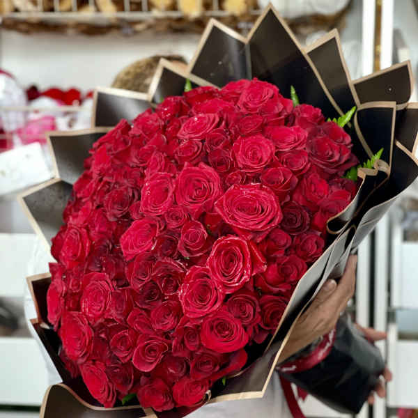 Large bouquet of red roses wrapped in black paper
