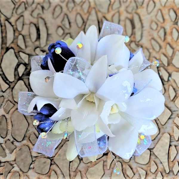 White and dark blue floral corsage with sheer ribbon and sparkly accents