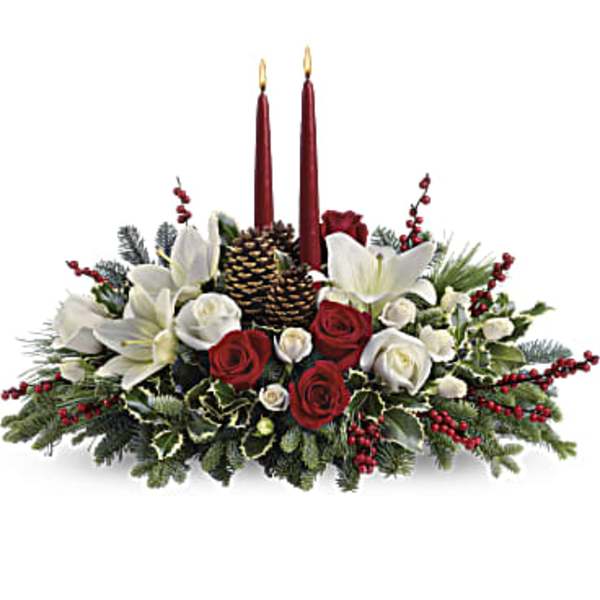 Holiday centerpiece with red candles, white lilies, and red and white roses