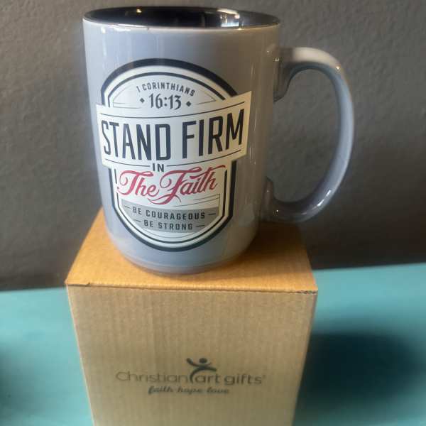 Gray mug with a faith message sitting on a cardboard box