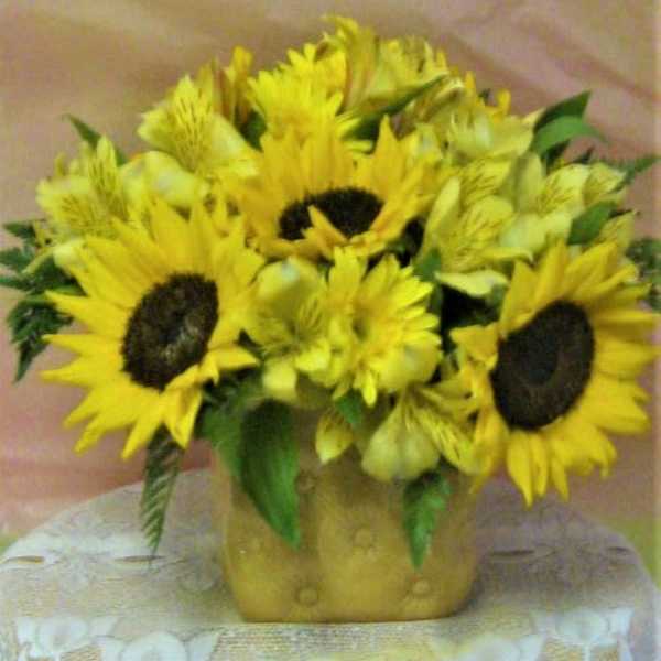 Bouquet of yellow sunflowers and alstroemeria in a gold vase