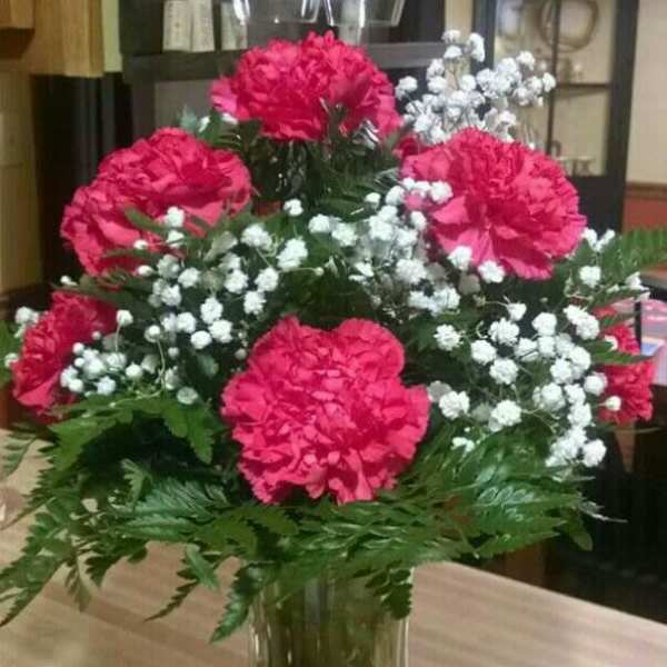 Pink carnations and white baby's breath in a clear glass vase