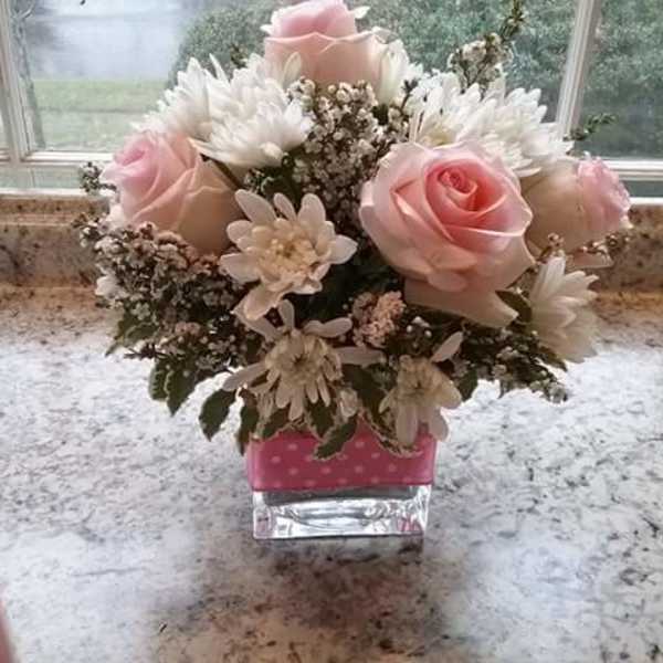 Pink roses and white daisies in a small glass vase