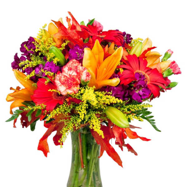 Bright mixed bouquet of lilies, gerbera daisies, and carnations in a glass vase