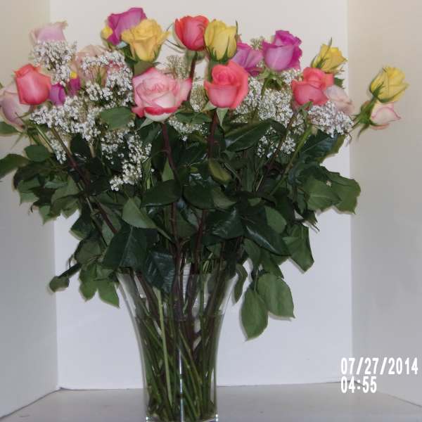 Bouquet of pink and yellow roses in a clear glass vase