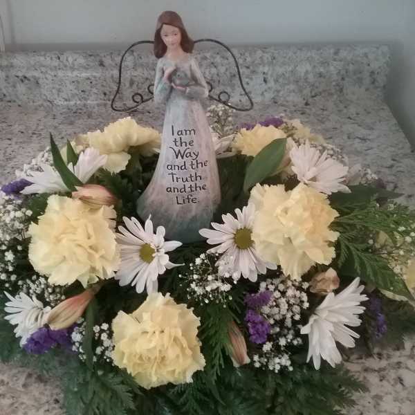 Floral wreath with a figurine centerpiece on a countertop