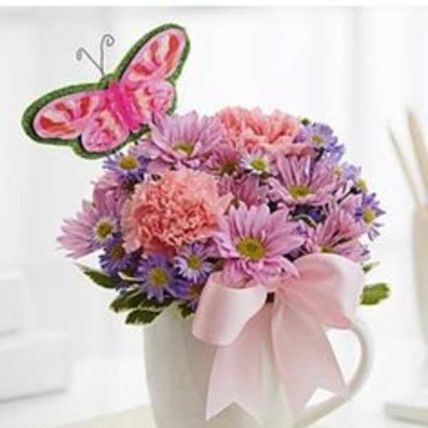 Pink and purple bouquet in a white mug with a butterfly pick