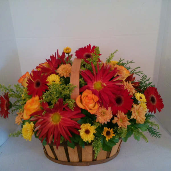 Basket of red, orange, and yellow flowers with a handle