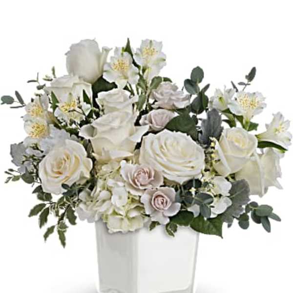 White rose arrangement in a clear square vase