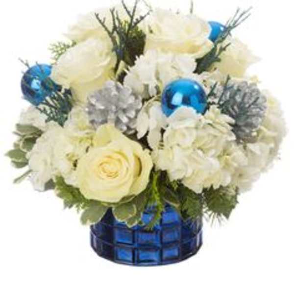 White roses and hydrangeas in a blue glass vase with blue ornaments