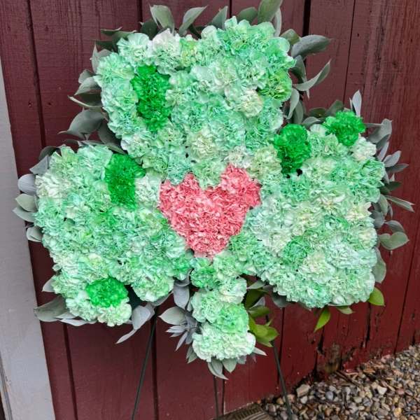 Heart-shaped floral easel spray with a pink center and green carnations