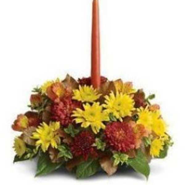 Autumn floral centerpiece with a tall orange taper candle