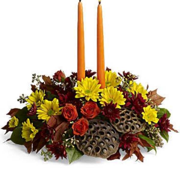 Autumn floral centerpiece with two orange taper candles