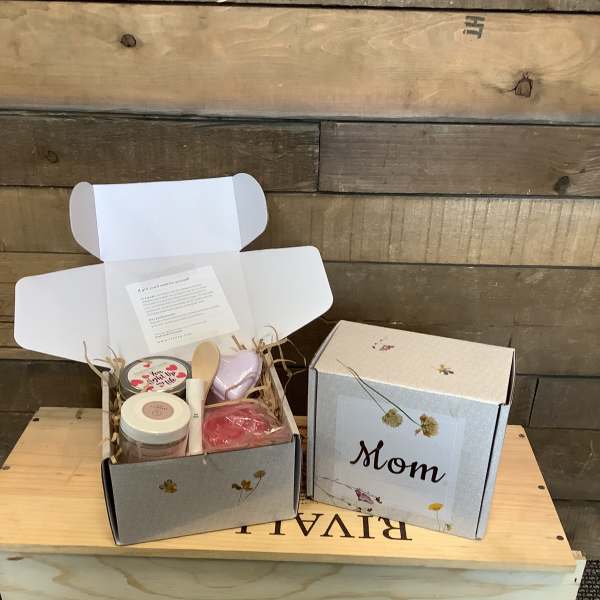 Two open gift boxes with candles and bath items, one labeled Mom