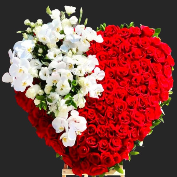 Heart-shaped arrangement of red roses with white orchids