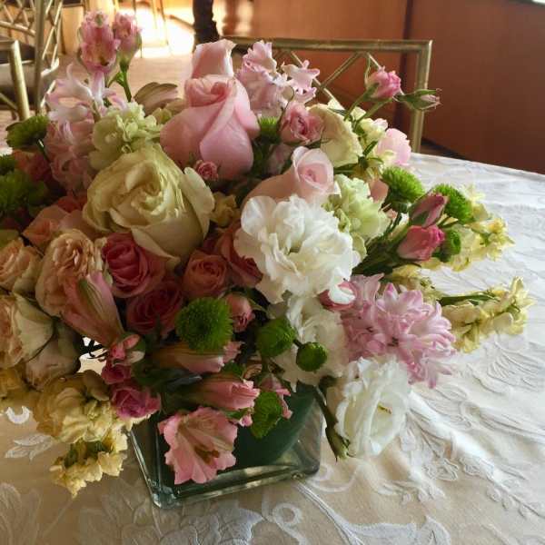 Pink and white mixed flower arrangement in a square glass vase