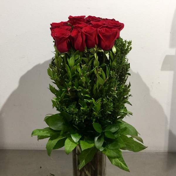 Tall bouquet of red roses in a clear glass vase