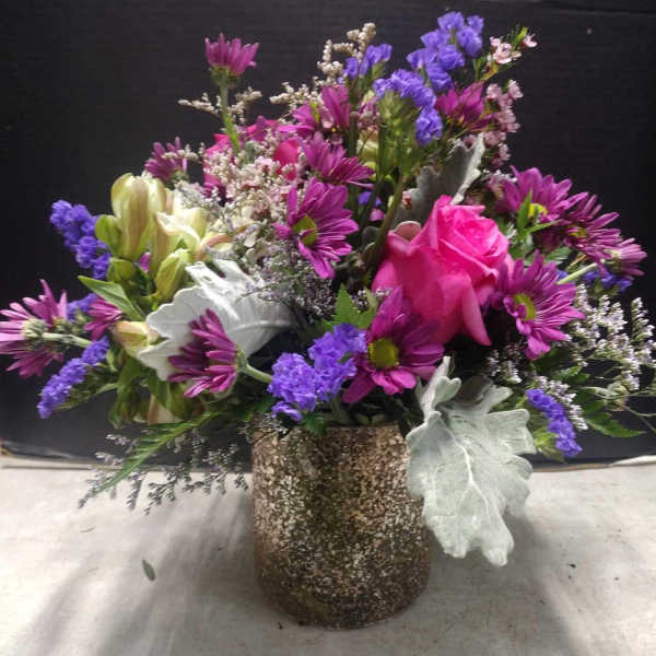 Mixed bouquet with pink rose, purple daisies, and a speckled vase