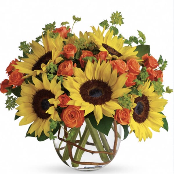 Bouquet of yellow sunflowers and orange roses in a clear glass vase