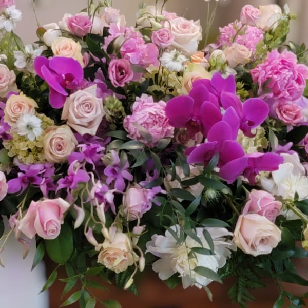 Large pink and white floral arrangement with roses and orchids