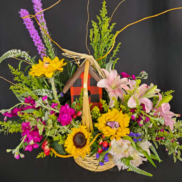 Basket arrangement with sunflowers, pink lilies, and purple flowers