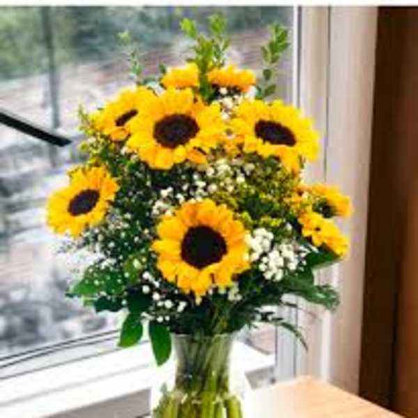 Bouquet of yellow sunflowers in a clear glass vase