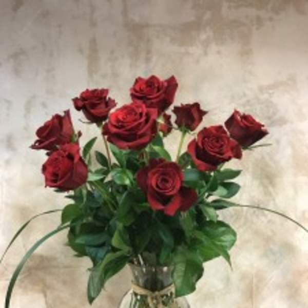 Red roses arranged in a clear glass vase