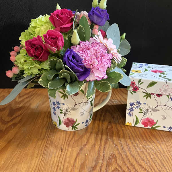 Mixed bouquet in a floral mug beside a matching gift box