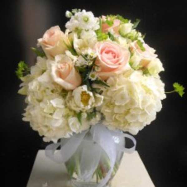 Bouquet of pale pink roses and white hydrangeas in a glass vase