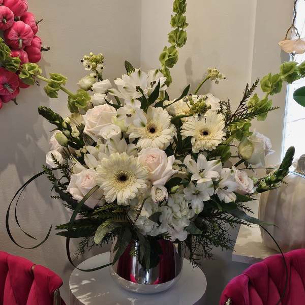 White and blush floral arrangement in a silver vase