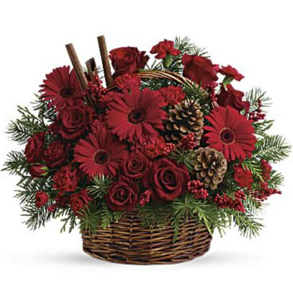 Red floral arrangement in a wicker basket with pinecones and evergreen accents