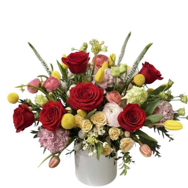Bouquet of red roses and mixed blooms in a white vase