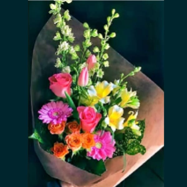 Mixed bouquet with pink roses, gerbera daisies, and yellow-white blooms