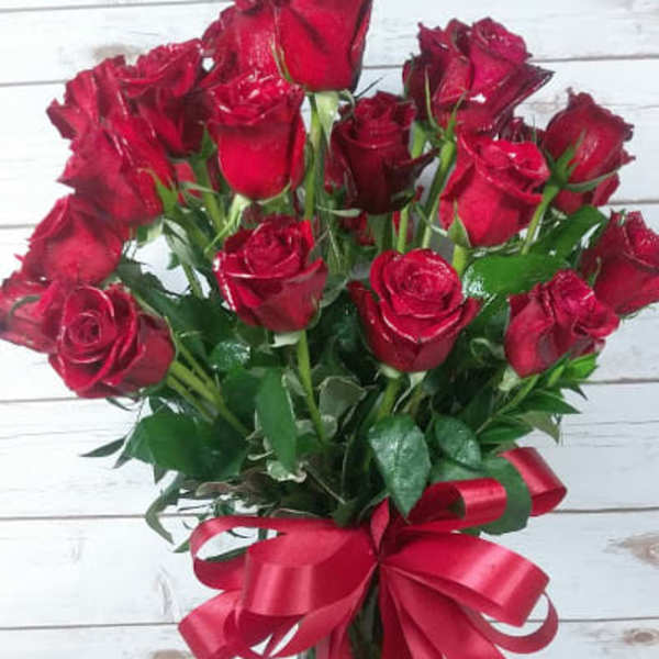 Bouquet of red roses in a glass vase with a red ribbon