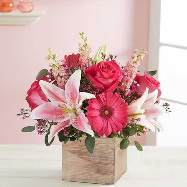 Pink and white flower arrangement in a wooden box