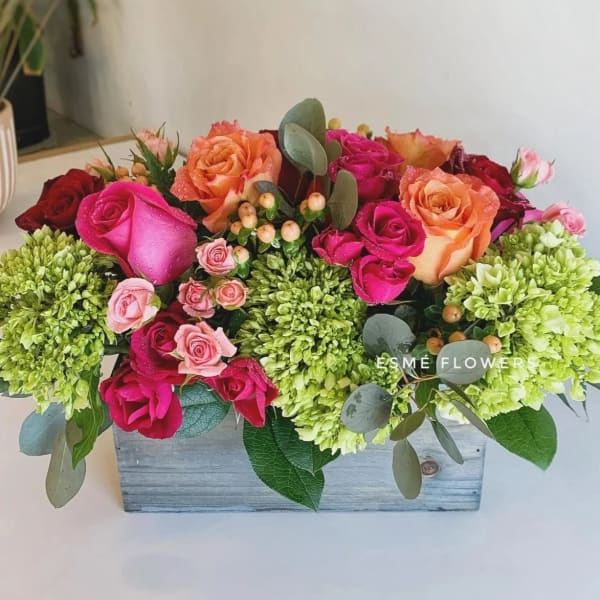 Mixed roses and green hydrangeas in a wooden box