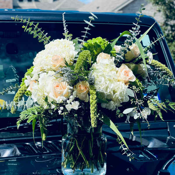 White and blush rose arrangement in a clear glass vase