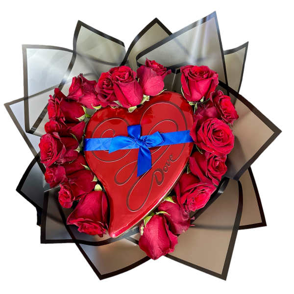Red roses arranged around a heart-shaped box with a blue ribbon