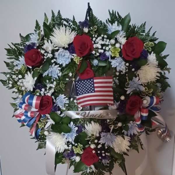 Heart-shaped floral wreath with red roses and an American flag