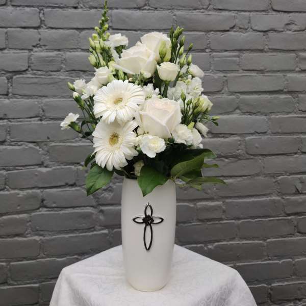 White roses and gerbera daisies in a tall white vase