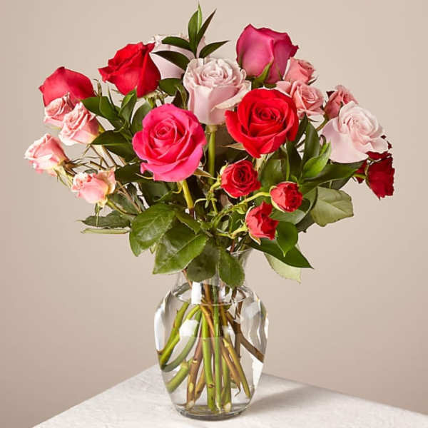 Bouquet of red and pink roses arranged in a clear glass vase
