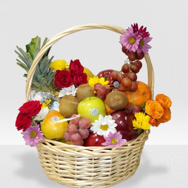 Wicker basket filled with assorted fresh fruit and colorful mixed flowers