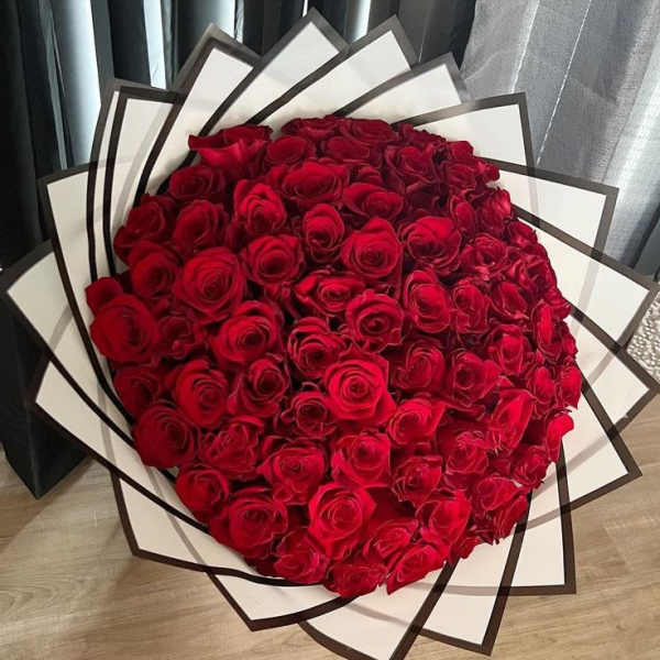 Large bouquet of red roses wrapped in white and black paper