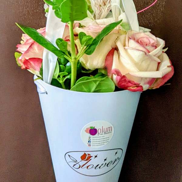 Pink and white roses in a white hanging cone holder