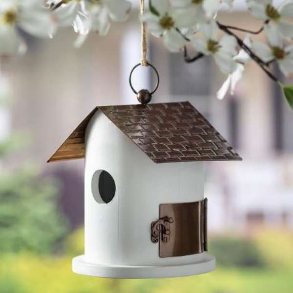 White hanging birdhouse with a brown roof and small round entrance