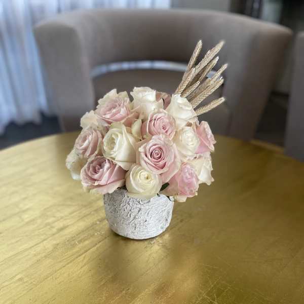 Pink and white rose bouquet in a small textured vase